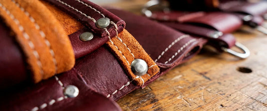 Close-up of reinforced leather tool belt stitching, rivets, and suede lining showing durable construction.