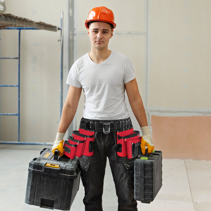 Construction worker in white t-shirt and orange hard hat wearing a red and black 26-pocket tool belt while holding two toolboxes on jobsite